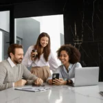 Três profissionais discutindo em reunião de trabalho sobre stakeholders estratégicos.